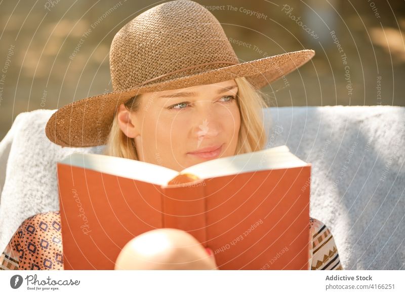 Fröhliche weibliche Touristin liest ein Buch, während sie sich auf einem Liegestuhl ausruht Frau lesen ruhen Kälte schön reisen Glück Feiertag