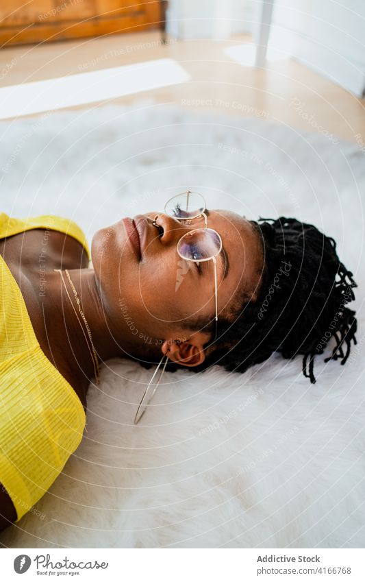 Junge schwarze Frau entspannt sich zu Hause auf dem Boden liegend Lügen Teppich ruhen sich[Akk] entspannen heimwärts Freizeit Wochenende Komfort gemütlich