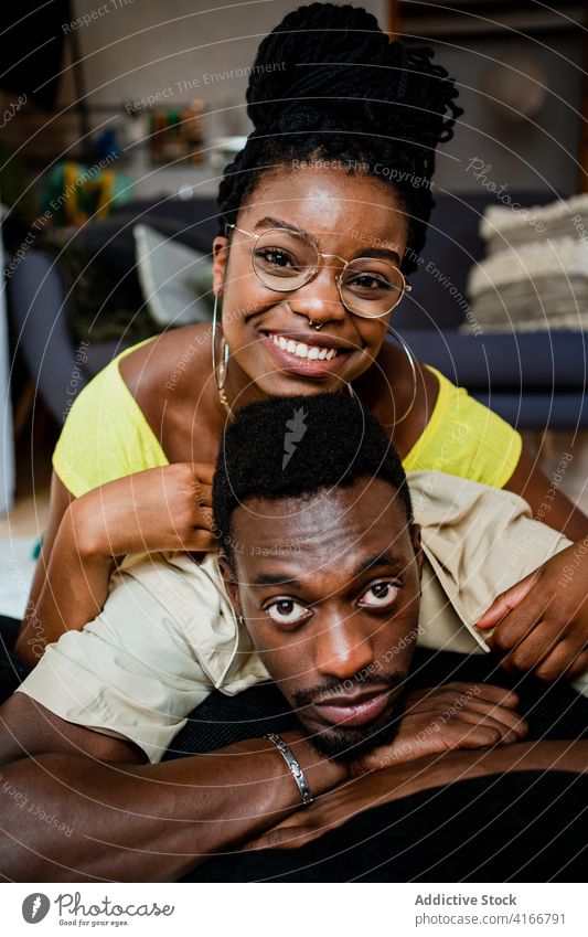 Fröhliche junge afroamerikanische Paar kuscheln, während auf dem Boden zu Hause liegen Lügen Zeit verbringen Zusammensein Glück Liebe romantisch