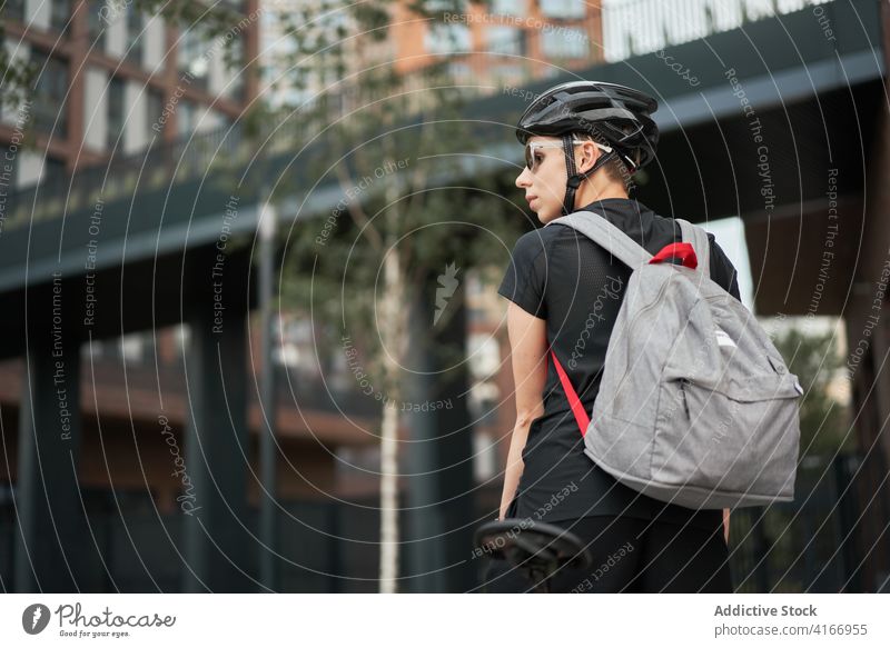 Radfahrerin mit Rucksack im Freien an einem Sommertag Gebäude für Radfahrer Baustein Großstadt Tag Frau jung Sport Reiten Schutzhelm schützend Sonnenbrille