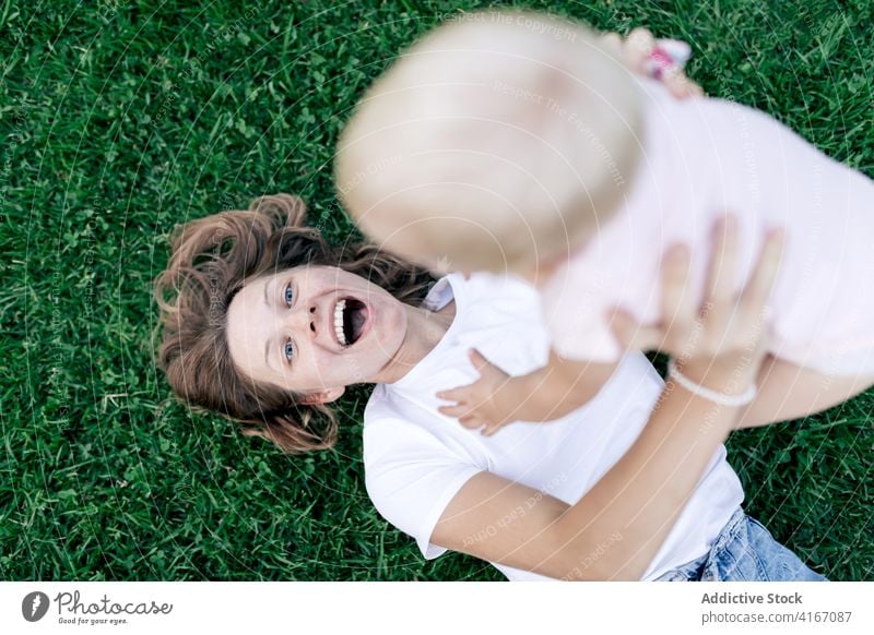 Mutter knuddelt überraschtes Kind im Park bezaubernd niedlich lustig Säugling Umarmen kuscheln Wochenende heiter Glück blond Bonden Zusammensein Kindheit Lachen
