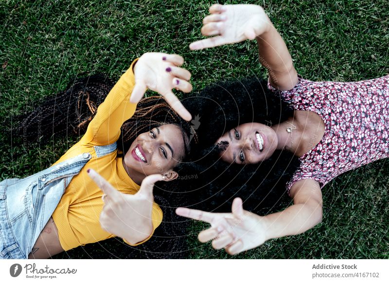 Inhalt schwarze Frauen auf Gras im Park Freundschaft Lügen Freundin Zusammensein Lächeln Sommer ethnisch Afroamerikaner Wochenende sorgenfrei Freude positiv