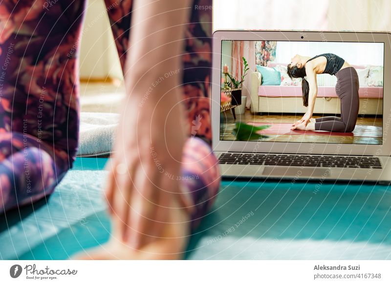 Schöne fit Frau Streaming Broadcast-Video-Blog über Yoga und Fitness im Wohnzimmer. Gesunder Lebensstil und soziale Medien. Frau beobachten Video-Tutorials auf Laptop und arbeiten zu Hause.