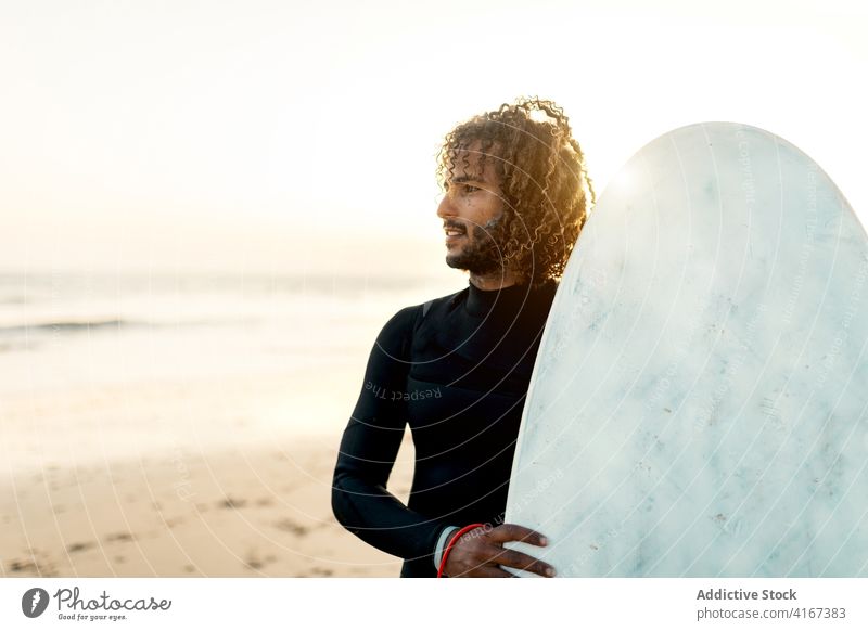 Fröhlicher Surfer mit Skimboard Mann heiter Sonnenuntergang Meeresufer Freiheit tropisch Wassersport männlich Resort ethnisch MEER Strand Sommer Badeanzug Typ