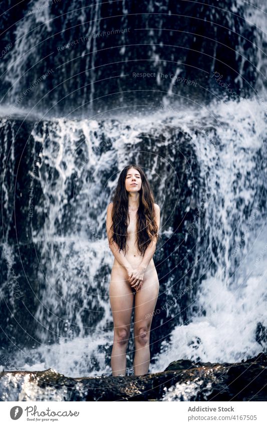 Nackte Frau in der Nähe eines Wasserfalls im Sommer nackt Natur sorgenfrei ruhig Deckung Körper Freiheit genießen Vergnügen friedlich idyllisch sinnlich
