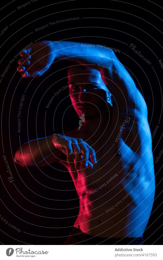 Sportlicher Mann tanzt im Studio beweglich Tänzer ausführen agil ernst Konzentration Athlet muskulös neonfarbig männlich gutaussehend maskulin sportlich