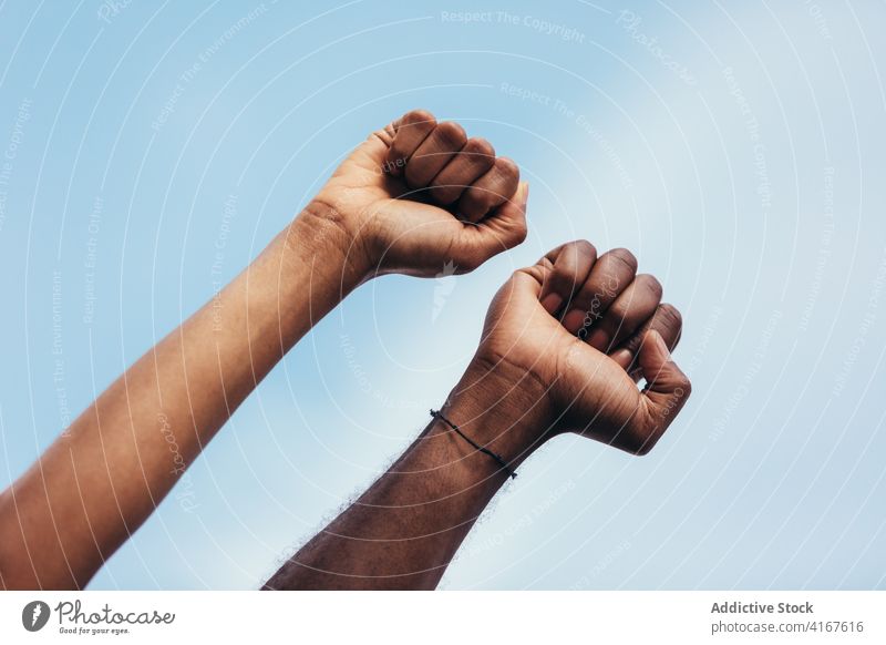 Fäuste schwarzer Menschen gegen einen blauen Himmel Mann Detailaufnahme männlich Faust Hand Person menschlich Kraft vereinzelt Hintergrund gestikulieren Finger