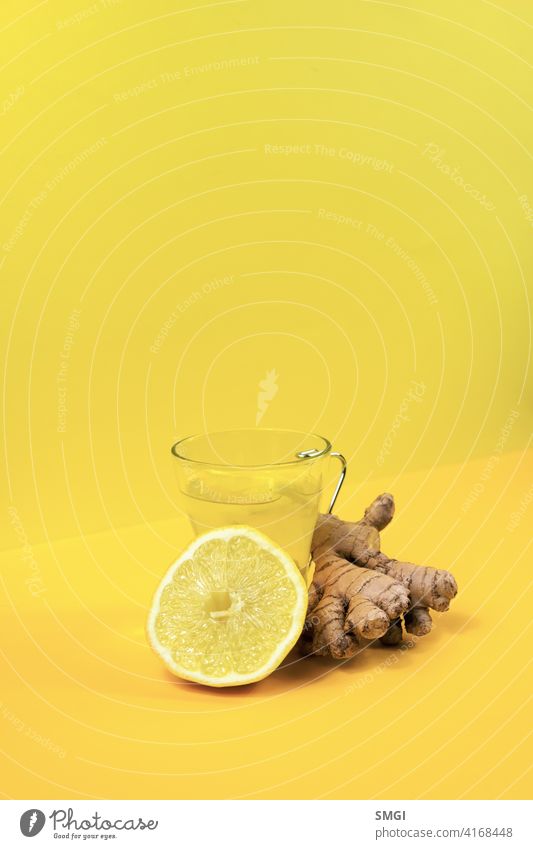 Glastasse mit Ingwer und Zitrone Tee, auf einem gelben Hintergrund zusammen mit seinen Zutaten. trinken Tasse Medizin Gesundheit Wurzel Kräuterbuch heiß