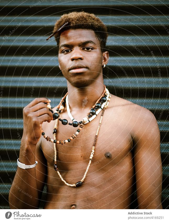 Seriöser schwarzer Mann mit modischem Schmuck auf der Straße Halskette golden trendy jung Reichtum ernst modern urban männlich ethnisch Afroamerikaner Mode