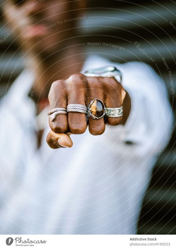 Nicht erkennbarer ethnischer Mann, der die Faust mit den Fingern in die Kamera zeigt Ring Silber Stil Hand Accessoire Schmuck trendy cool männlich schwarz