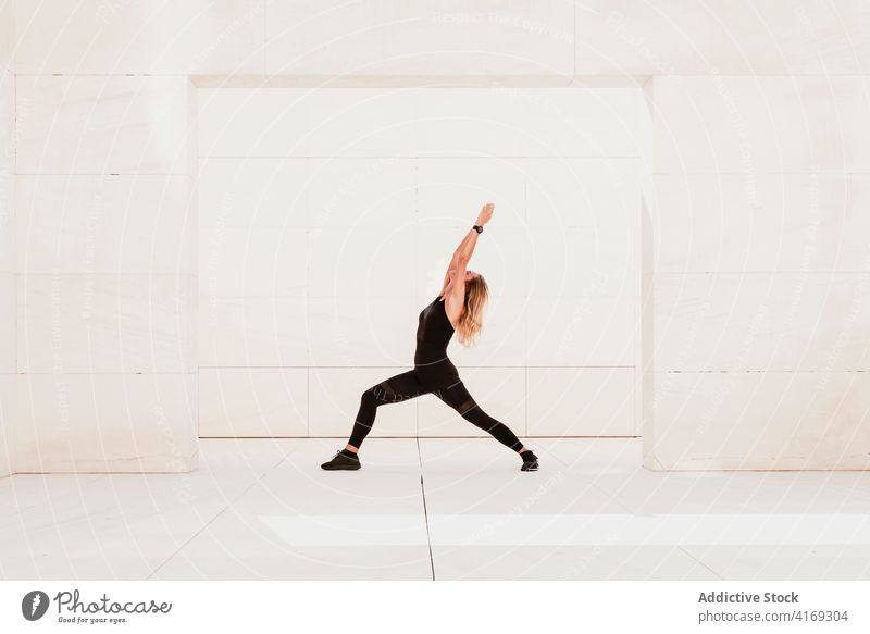 Schlanke Frau streckt ihren Körper in Yoga-Pose Ausfallschritt Dehnung Gleichgewicht üben positionieren Asana stehen beweglich passen Wellness schlank