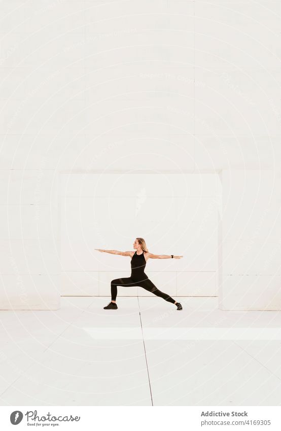 Frau übt Krieger Yoga-Pose virabhadrasana Gleichgewicht üben positionieren Asana stehen beweglich passen Wellness schlank Körperhaltung Energie Wohlbefinden