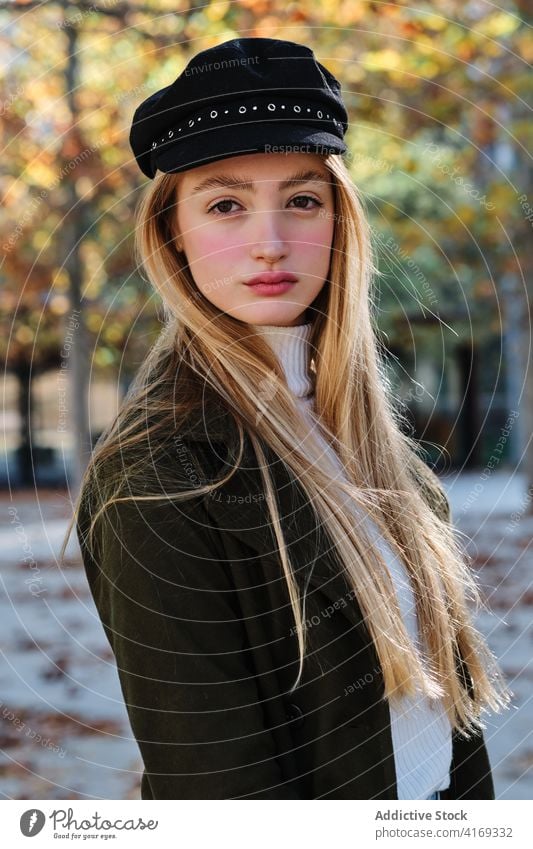 Millennial-Frau mit trendiger Mütze im herbstlichen Park Stil Verschlussdeckel Hut Herbst Mode trendy urban lässig jung blond Outfit Saison Lifestyle Dame