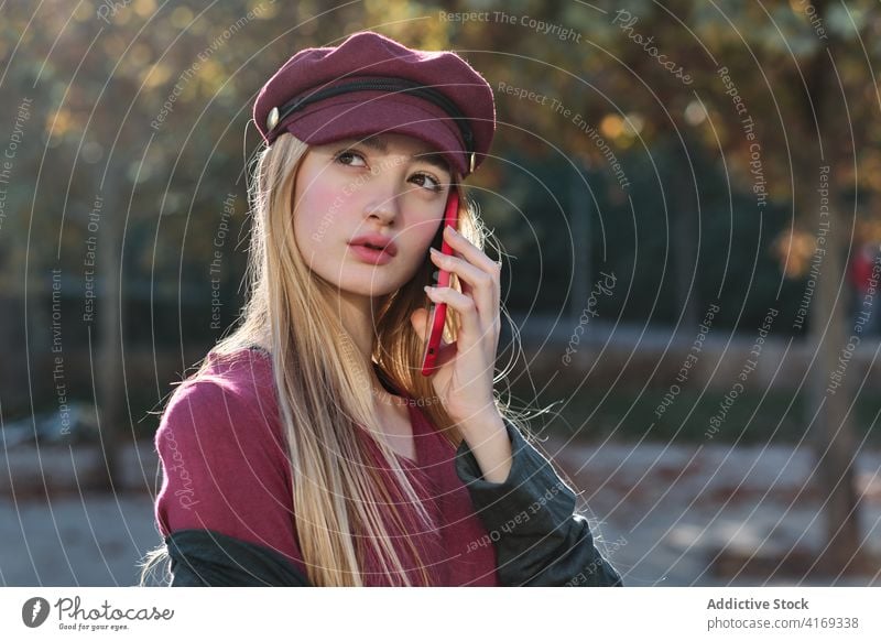 Stilvolle junge Frau telefoniert im Herbst im Park Smartphone reden trendy Mode Telefon farbenfroh rot tausendjährig Hut Gerät Apparatur Anschluss modern Mobile