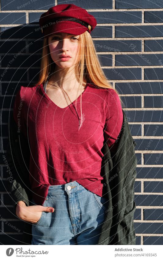 Trendy junge Frau im Herbst Outfit stehen in der Nähe von Wand Stil Mode Verschlussdeckel Farbe rot trendy modern urban lässig Hipster Kopfbedeckung blond Stoff