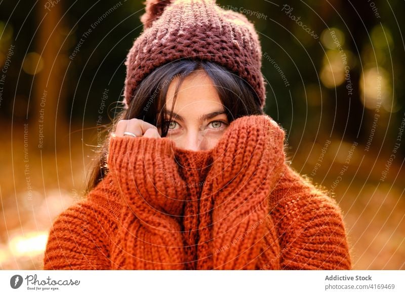 Frau in warmer Kleidung friert im Herbstwald kalt gestrickt Pullover Hut Wetter warme Kleidung Farbe Porträt fallen jung Natur Saison Park farbenfroh hell