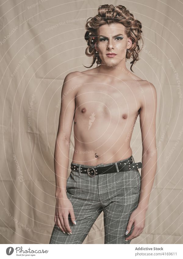 Hemdloser androgyner Mann mit eleganter Frisur Make-up ohne Hemd Stil krause Haare schlank Transgender männlich jung Model queer lgbtq Glamour Vorschein trendy