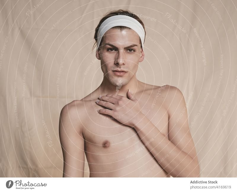 Sinnliches androgynes männliches Modell berührt den Hals Mann sinnlich Tasthals ohne Hemd schlank Transgender Verlockung Angebot Vorschein jung queer lgbtq