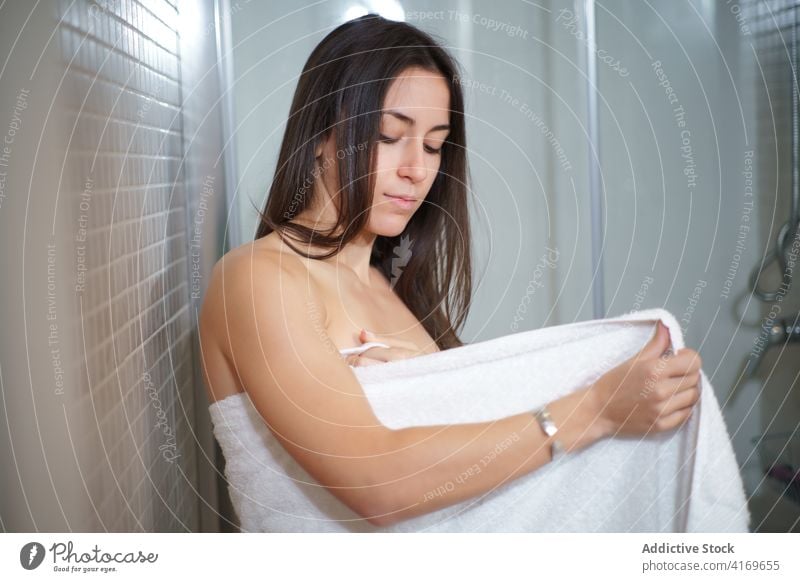 Frau wickelt sich nach dem Bad in ein Handtuch umhüllen Hygiene Routine täglich Hautpflege weich filigran Dusche Körperpflege Leckerbissen Wellness Gesundheit