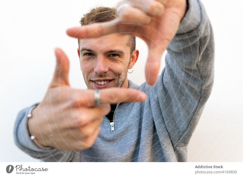 Fröhlicher Mann macht Rahmen mit Händen Finger Hand Fotografie Hipster heiter Lächeln gestikulieren Fokus jung Glück männlich positiv Optimist kreativ schießen