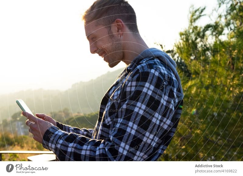 Glücklicher Mann liest Nachricht auf Smartphone benutzend Freude lesen Hipster Telefon Apparatur jung männlich Mobile Nachrichten Gerät Anschluss Browsen