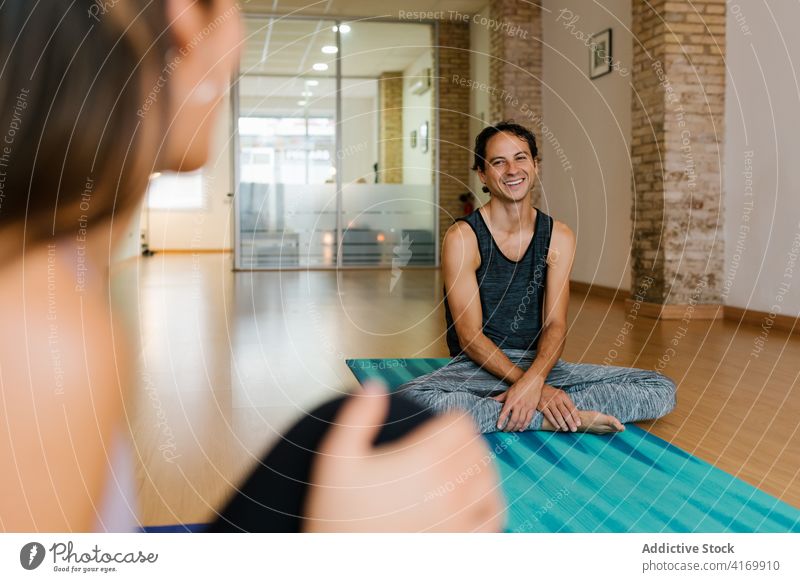 Mann lächelnd plaudernd im Yogastudio sprechen Atelier Lektion Lächeln Person Pause Menschengruppe Unterlage reden heiter sich[Akk] entspannen Gespräch ruhen