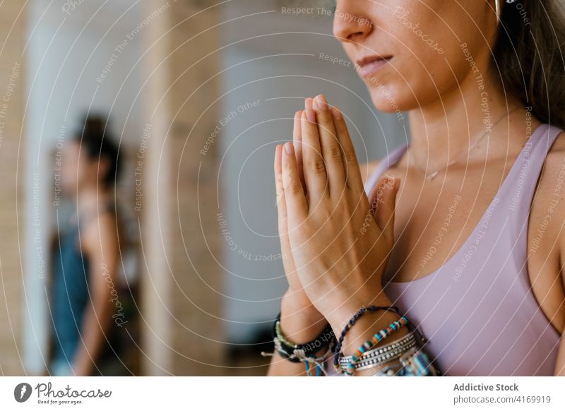 Anonyme Frau meditiert während einer Yogastunde meditieren Atelier Lektion Hände gefaltet üben Zen Sprit jung Menschengruppe Gleichgewicht Vitalität