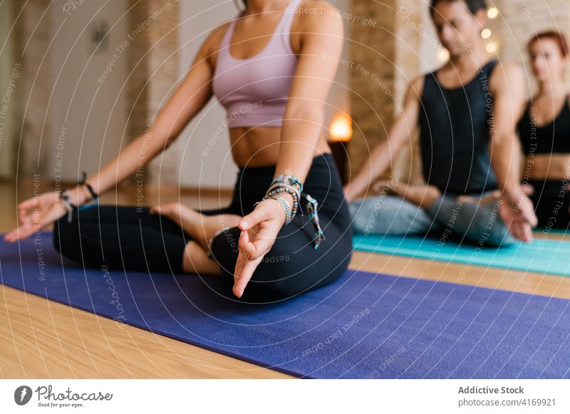 Crop-Frau meditiert mit Gruppe im Studio meditieren Yoga Atelier Menschengruppe Lektion Lotus-Pose Unterlage Achtsamkeit Zen Wellness Gelassenheit Gleichgewicht