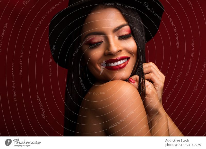 Lächelnde Frau mit roten Lippen im Studio rote Lippen Make-up Gesicht charmant Vorschein Hut Tastkopf Model heiter Optimist positiv Inhalt lebhaft pulsierend