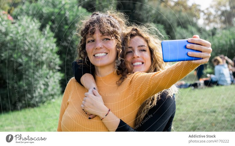 Fröhliche Freunde machen ein Selfie im Park Frauen Zusammensein Freundschaft heiter Spaß haben freundlich Smartphone charmant sonnig Wochenende Apparatur Gerät