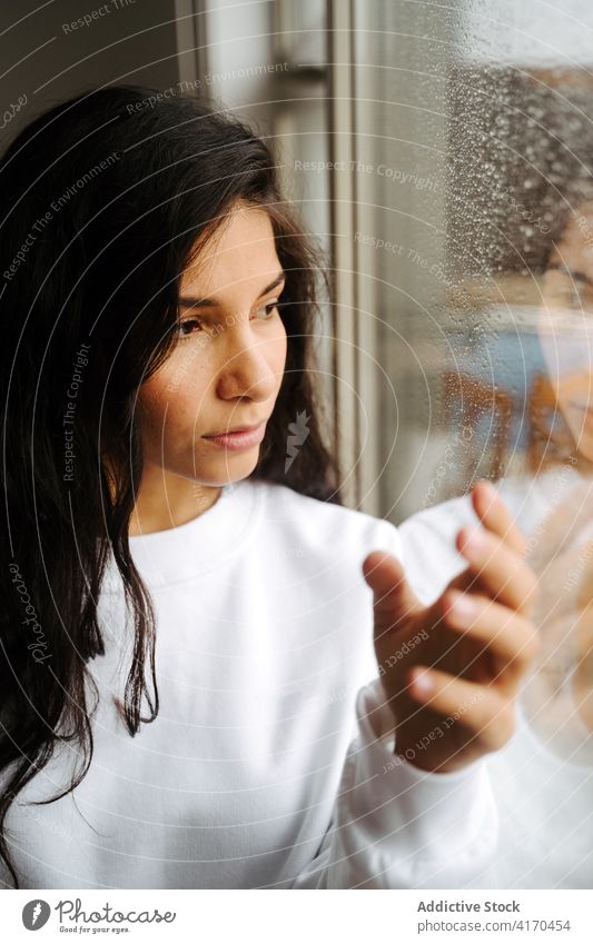 Friedliche Frau berührt Fenster mit Wassertropfen Regentropfen berühren Melancholie Stimmung Tröpfchen friedlich ruhig ethnisch Angebot Windstille Einsamkeit