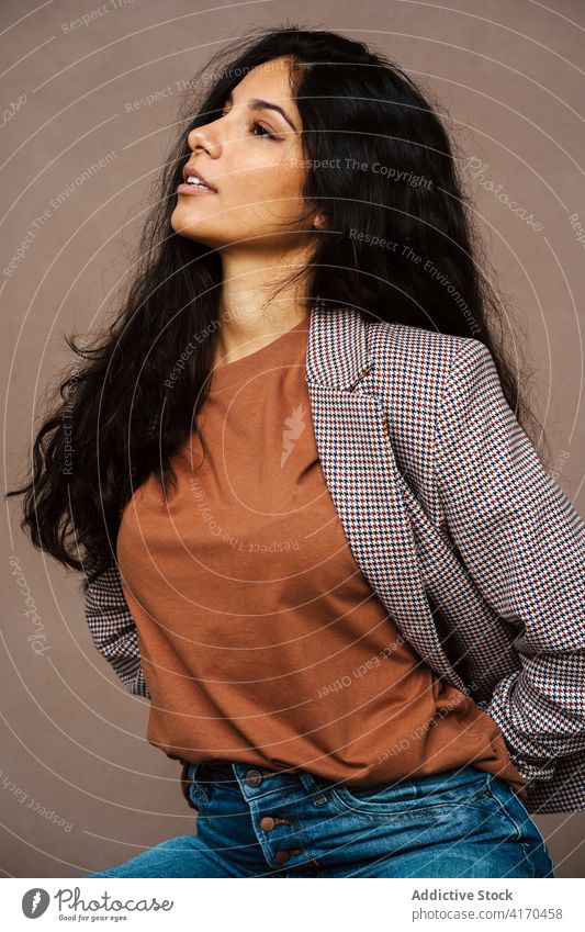 Frau in stilvoller Kleidung im Studio Stil Jacke trendy Atelier Model charmant ethnisch jung Vergnügen sich[Akk] entspannen Optimist modern genießen positiv