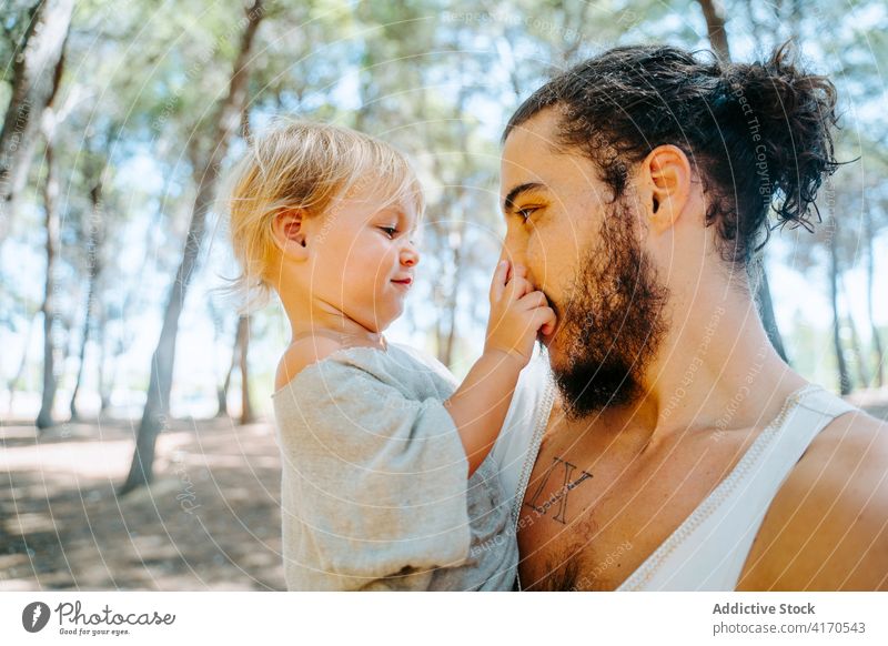 Glücklicher Vater knuddelt süßes Kind im Wald Kuss Wange Liebe niedlich Angebot Zusammensein Wochenende ethnisch rassenübergreifend vielfältig Elternschaft