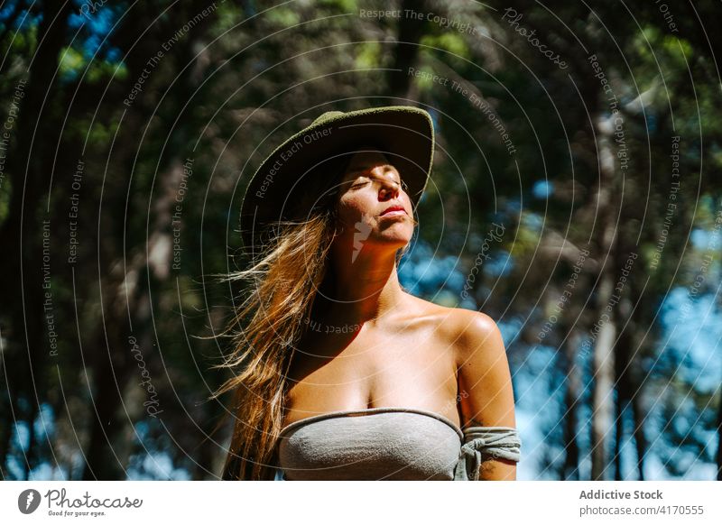 Sorglose Frau genießt die Natur im Wald sorgenfrei Freiheit genießen Augen geschlossen Wind Sonnenlicht sanft Hippie Hipster Hut Top friedlich Wälder Sommer