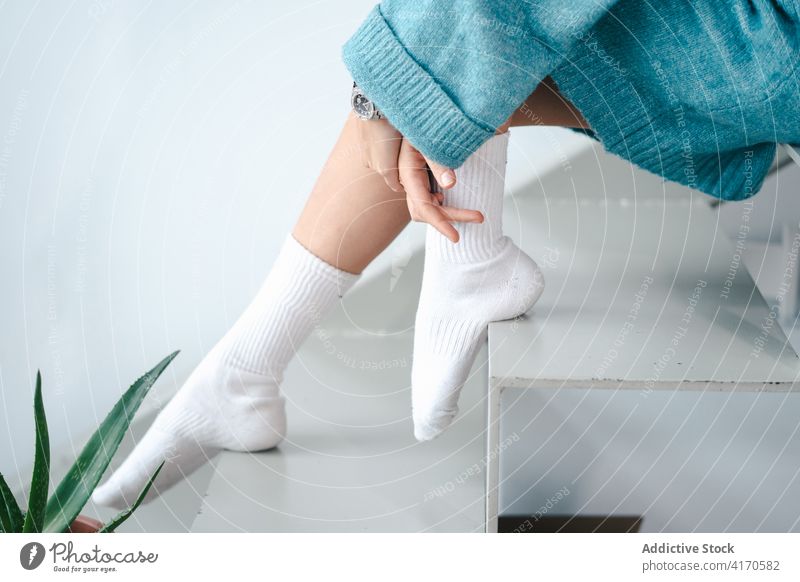 Frau in weißen Socken zu Hause gemütlich heimisch Outfit Pullover Kniestrümpfe Anmut Angebot heimwärts Treppe warm hell ruhen Stil sitzen Schritt trendy