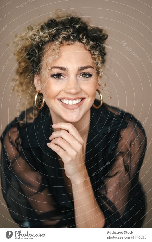 Glückliche Frau in schwarzem Outfit im Studio elegant Atelier sich auf die Hand lehnen charmant Vorschein Lächeln Zahnfarbenes Lächeln trendy Mode modern