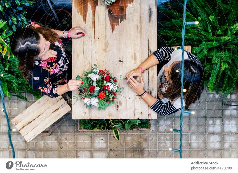 Frauen arrangieren Blumenstrauß im Geschäft Laden Blumenhändler Blütezeit Feier Stubenschmuck Design Zusammensein Dekoration & Verzierung Werkstatt horizontal