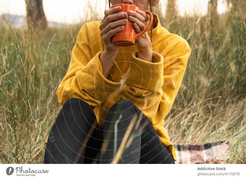 Anonyme Frau genießt frischen Tee auf dem Lande Heißgetränk trinken Feld Herbst Natur sorgenfrei genießen fallen Landschaft Getränk Wochenende Gelassenheit