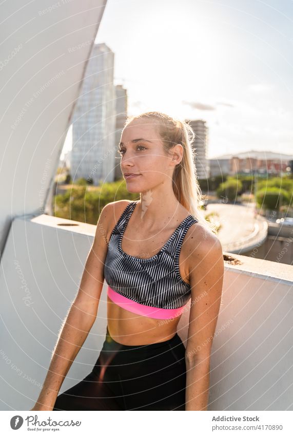 Schlanke Frau in Sportkleidung ruht sich nach dem Training auf der Terrasse aus Fitness sportlich ruhen urban passen Erholung jung Großstadt Athlet