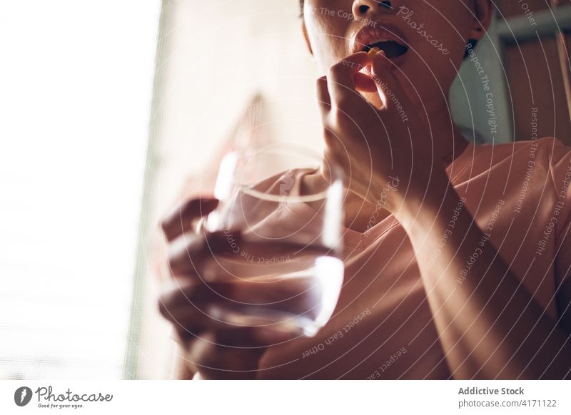 Frau mit Wasserglas, die eine Pille einnimmt Tablette nehmen gelb Vitamin Gesundheitswesen medizinisch Ergänzung Glas trinken Leckerbissen Medizin Medikament