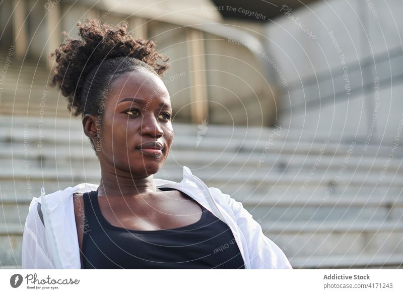 Schwarze Sportlerin entspannt sich auf einer Treppe in der Stadt Großstadt sich[Akk] entspannen Training Pause Athlet Frau selbstbewusst Sportbekleidung Läufer