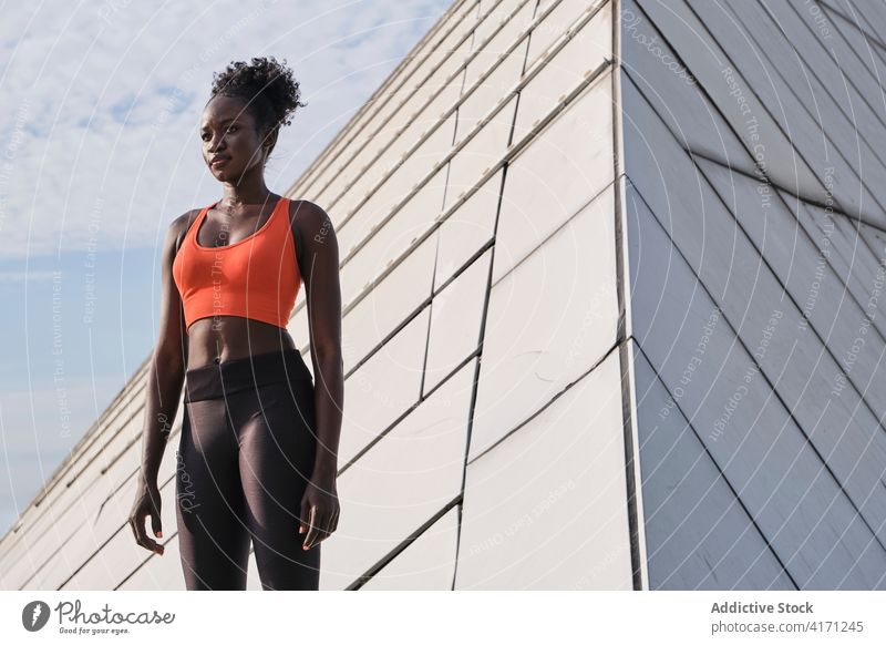 Fokussierte schwarze Sportlerin auf der Straße beim Training schlank Großstadt passen Athlet Bestimmen Sie Geometrie Konstruktion Form ernst Frau ethnisch