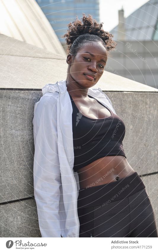 Entschlossene schlanke schwarze Sportlerin auf der Straße in der Stadt passen Sportbekleidung Großstadt Bestimmen Sie urban sportlich Gesundheit Athlet Frau