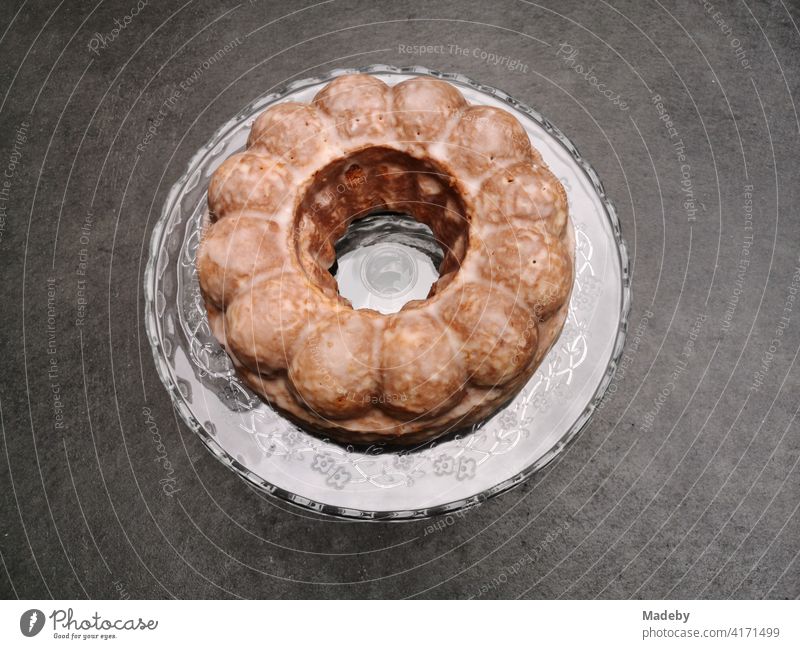 Runder Kuchen in klassischer Gugelhupf Kuchenform auf grauem Betonboden in einer Designerwohnung in Rudersau bei Rottenbuch im Kreis Weilheim-Schongau in Oberbayern