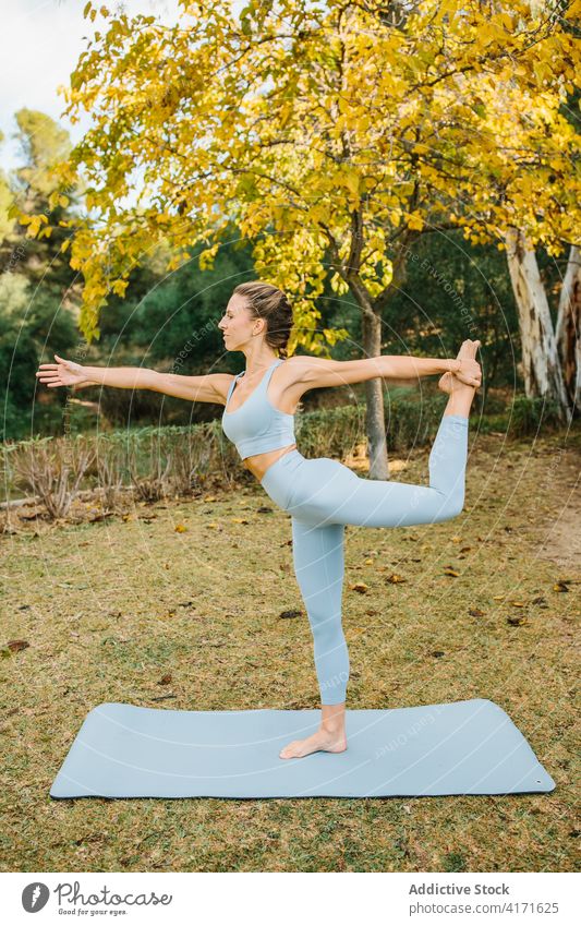 Frau in "Lord of the Dance"-Yoga-Pose im Park stehend Herr des Tanzes Natarajasana Asana Gleichgewicht Dehnung üben Wellness Lifestyle Harmonie Wohlbefinden Zen