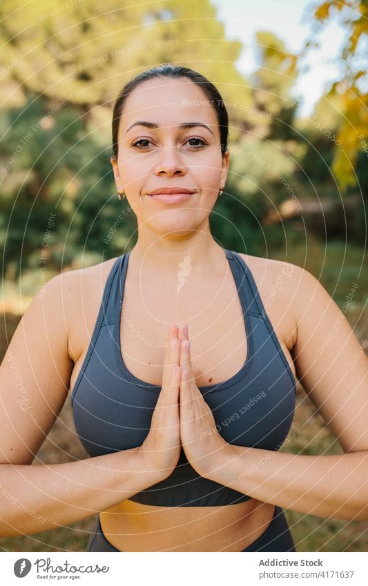 Lächelnde Frau beim Yoga im Park Namaste gestikulieren üben Achtsamkeit Gebet Hand Inhalt Zen Windstille Energie Harmonie friedlich Natur Vitalität Gesundheit