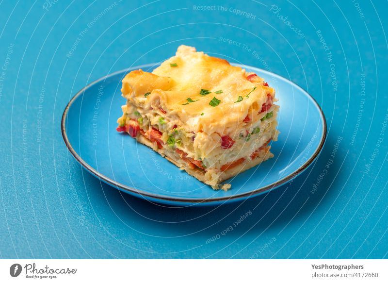 Vegetarische Lasagne auf einem blauen Teller. Einzelne Portion Lasagne Hintergrund gebacken Béchamelsauce Käse Nahaufnahme gekocht Textfreiraum Küche