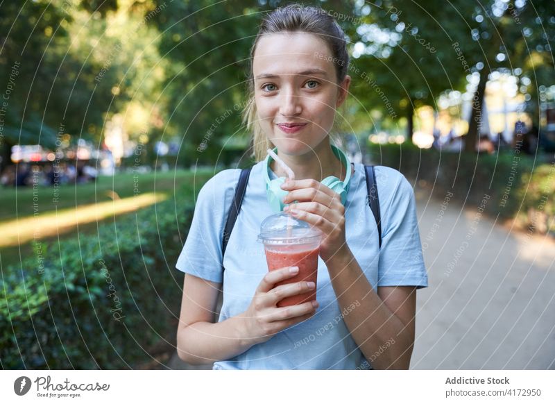 Glückliche Frau mit Getränk im Park stehend Sommer trinken Mädchen blond Teenager Lifestyle Freude jung genießen Kommunizieren positiv sorgenfrei Urlaub