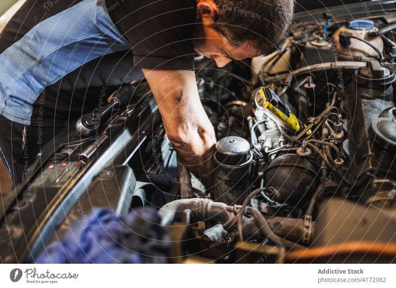 Techniker mit Taschenlampe bei der Untersuchung eines Automotors Mann Mechaniker prüfen Motor PKW Garage leuchten Arbeit Reparatur männlich Fahrzeug Verkehr