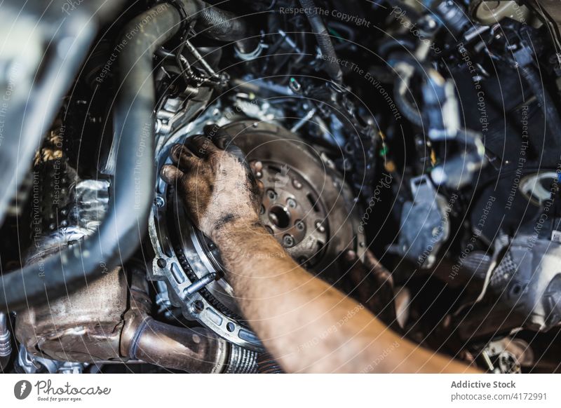 Crop-Mechaniker beim Einbau der Kupplungsscheibe im Auto Scheibe Motor installieren fixieren Garage dreckig Arbeit Dienst Job Fahrzeug Verkehr PKW Reparatur